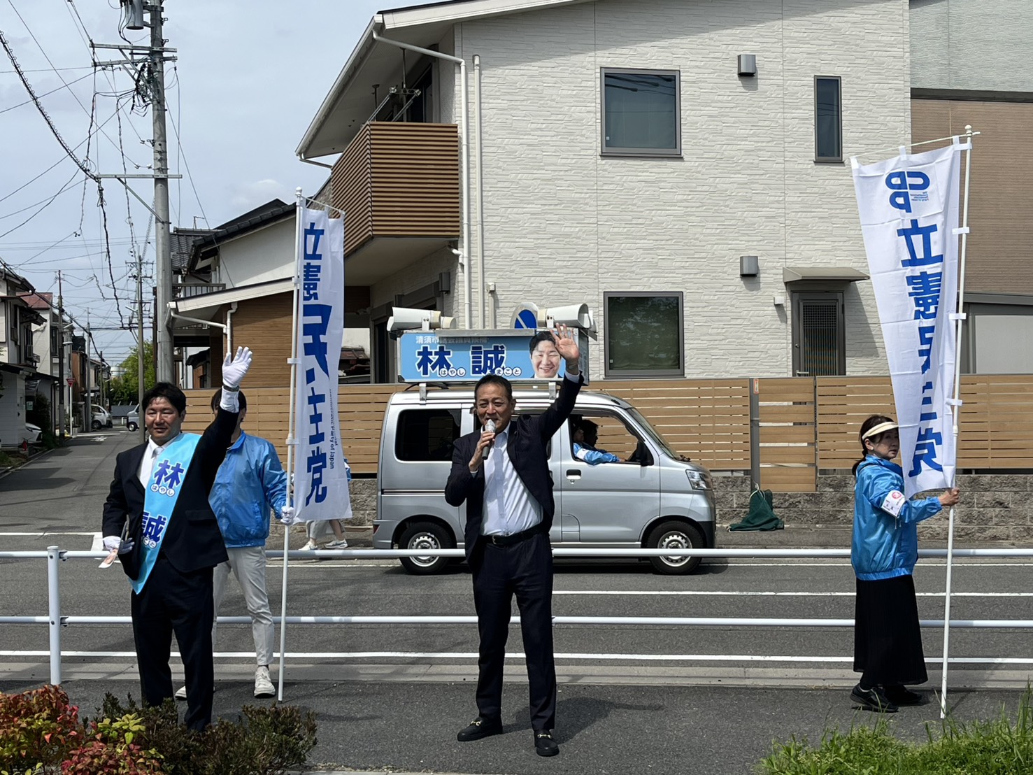のぼり旗を掲げて選挙カー前で活動