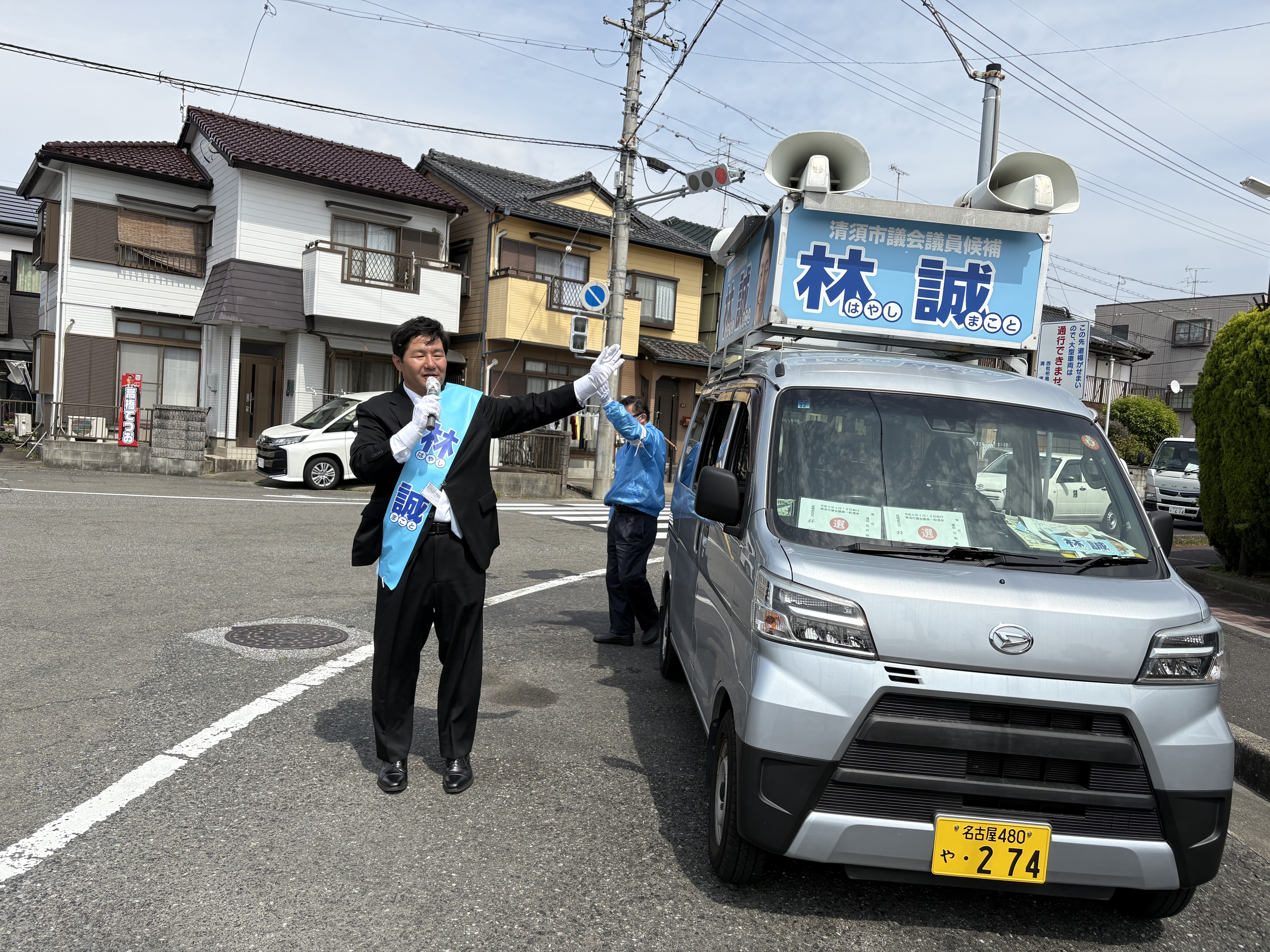 選挙カーの横で活動する林誠